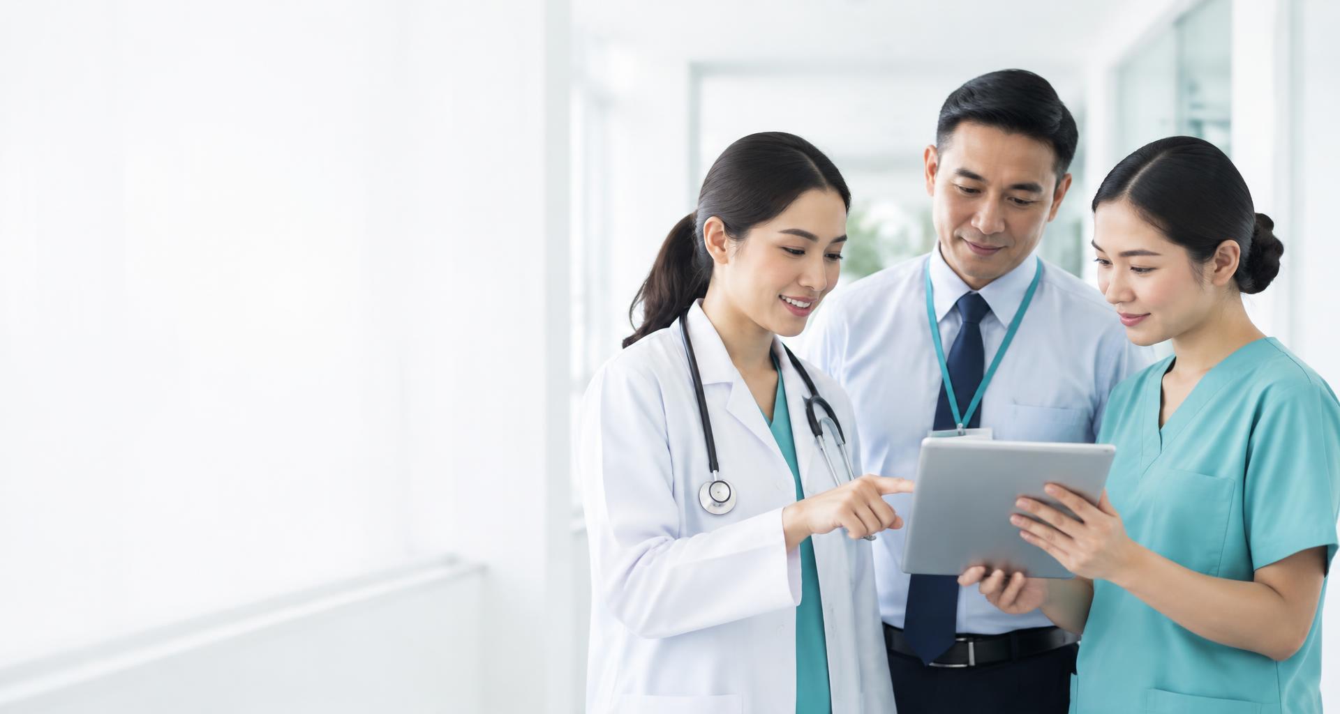 Southeast Asian healthcare professionals collaborating around a tablet